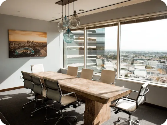 An office with a few chairs and a lookout on a city.